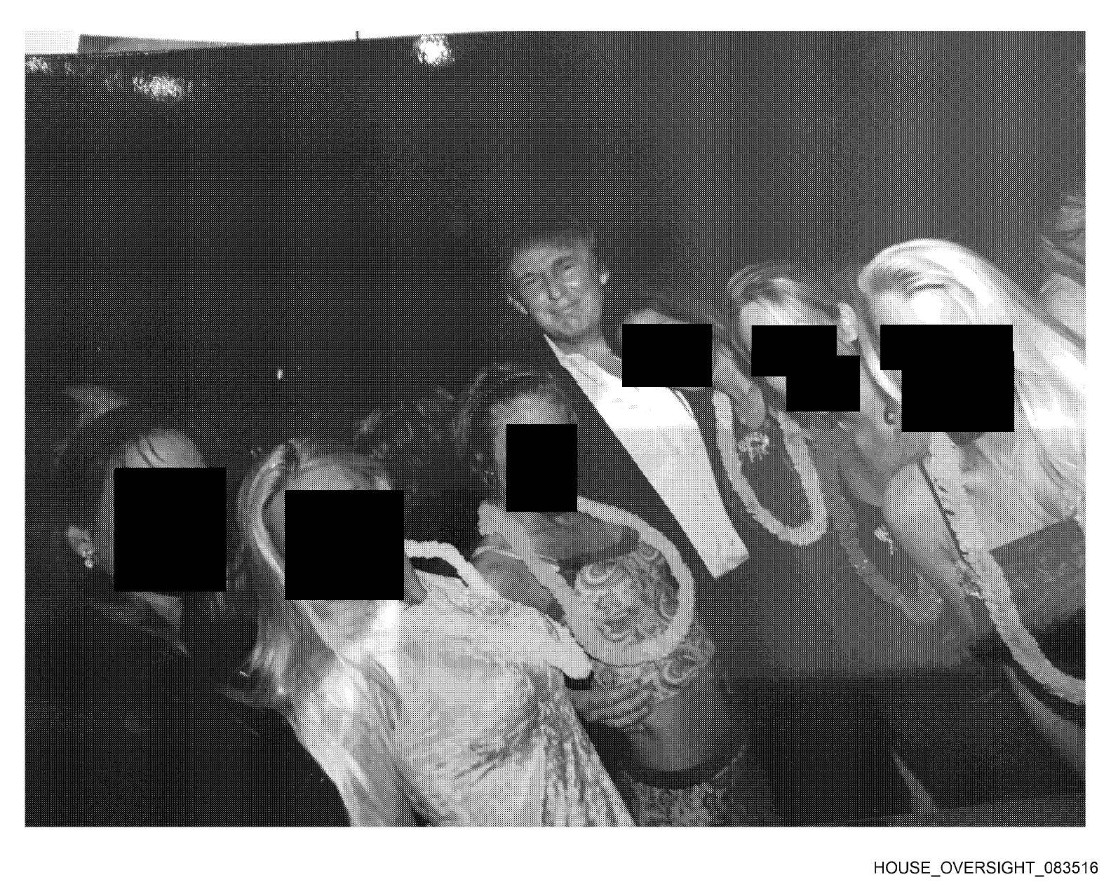 This undated, redacted photo released by Democratic lawmakers on the House Oversight Committee shows Donald Trump standing with a group of women. (House Oversight Committee via AP).
