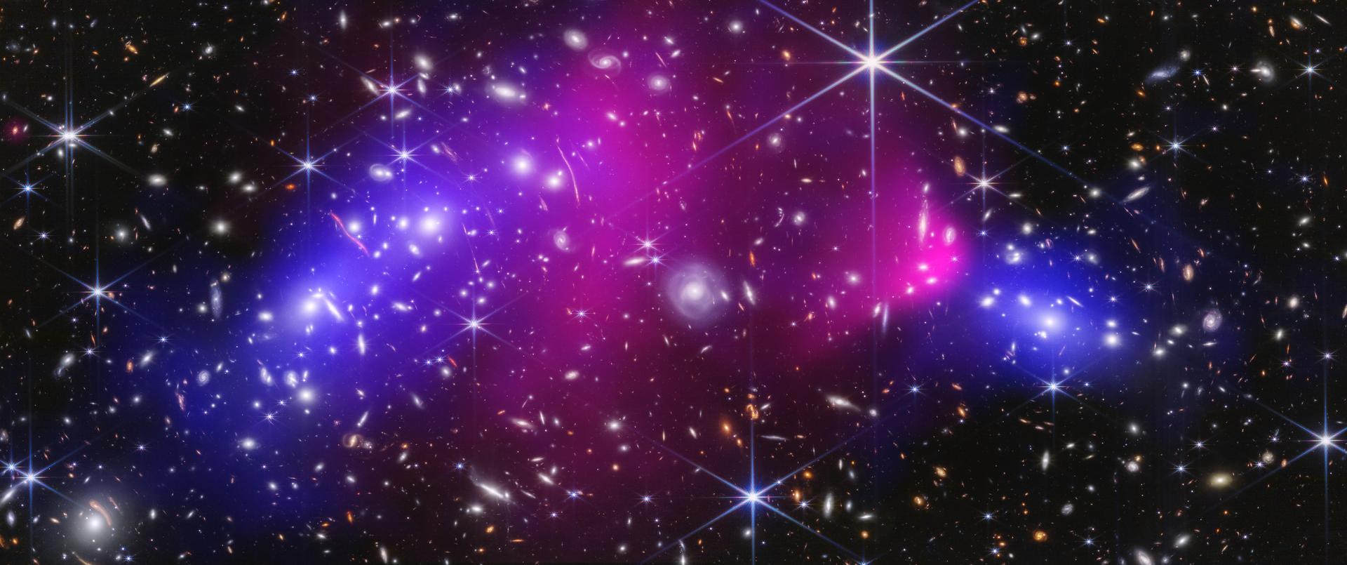 This NASA image shows two massive galaxy clusters previously captured by NASA's James Webb Space Telescope and Chandra X-ray Observatory, with areas of possible dark matter in blue. (NASA via AP)