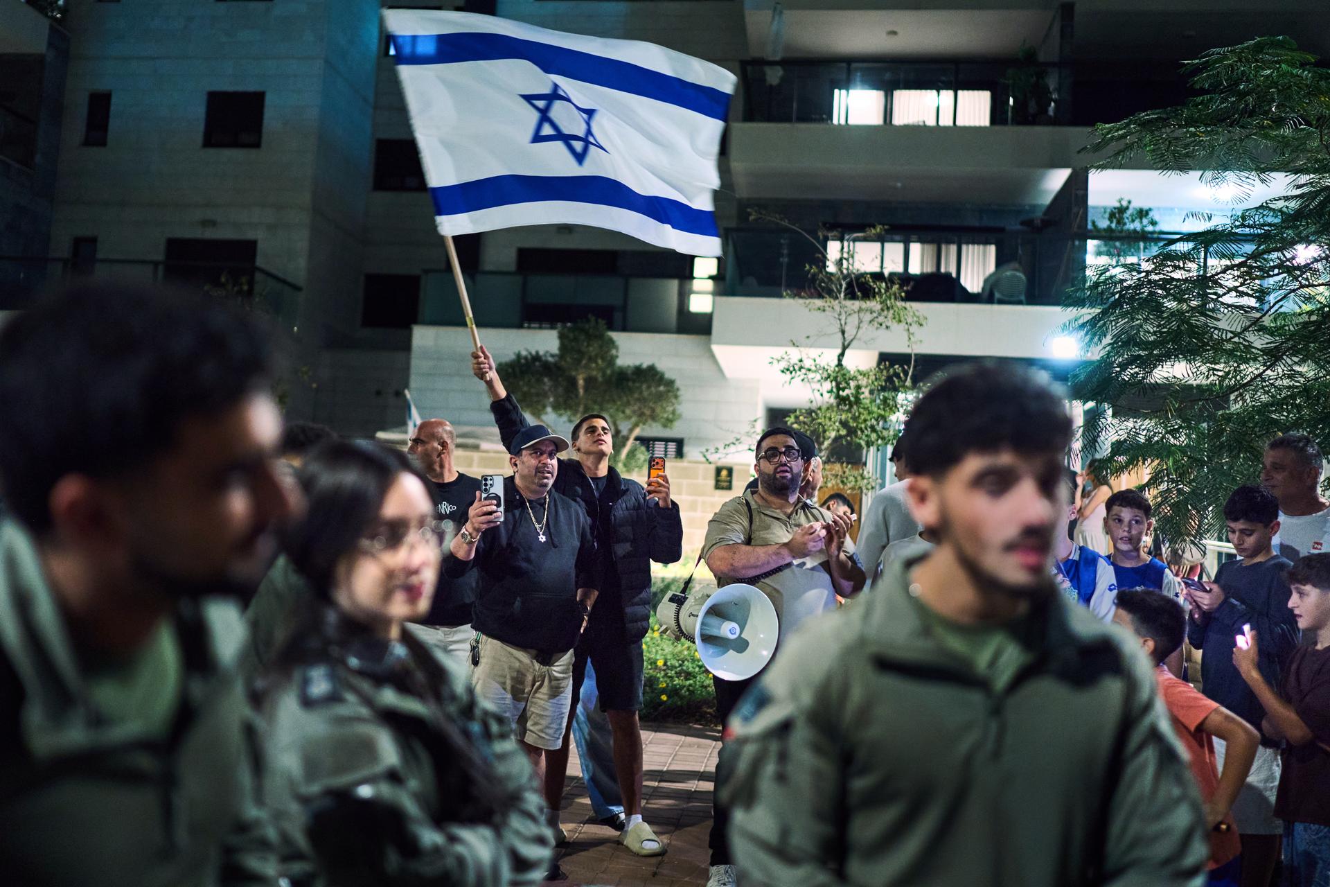 Supporters of Prime Minister Benjamin Netanyahu, rear, are separated by police as they argue with left-wing activists calling for a government with Arab parties outside the residence of Yashar party leader Gadi Eisenkot in Herzliya, Israel, Thursday.