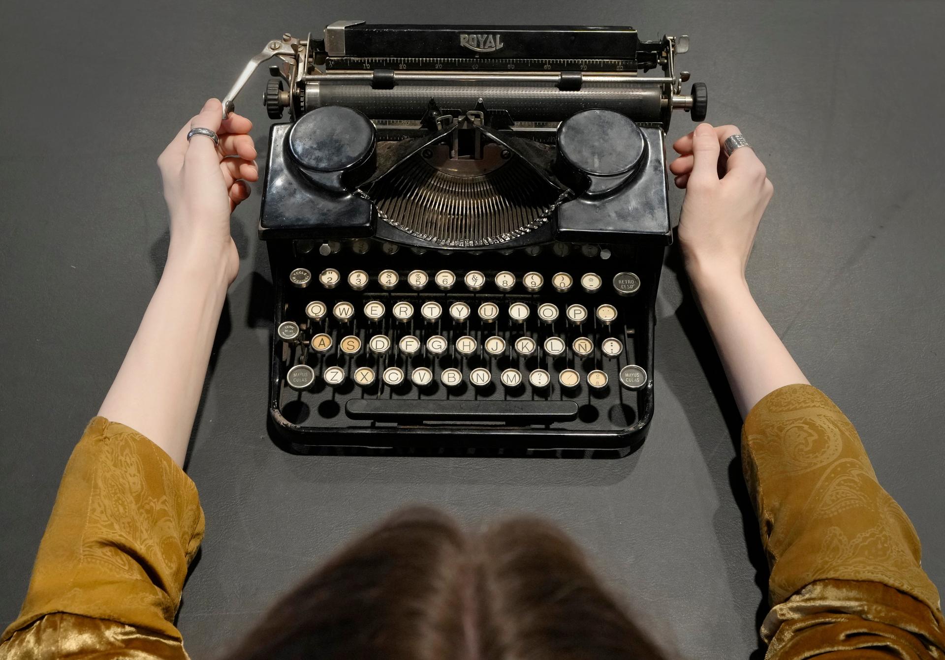 A Bonhams employee displays a typewriter, manufactured circa 1931, at Bonhams auction house in London, 2022.