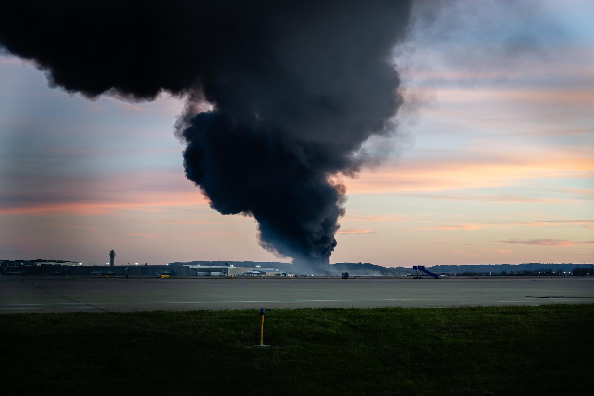 A plume of smoke rises from the site of a UPS cargo plane crash at Louisville Muhammad Ali International Airport on Tuesday. (AP Photo/Jon Cherry)