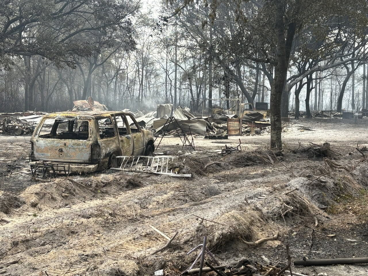 This photo provided by the Georgia Department of Natural Resources shows burned vehicles and trees from the Pineland Road Fire in southeast Georgia on Wednesday. (Georgia Department of Natural Resources via AP)