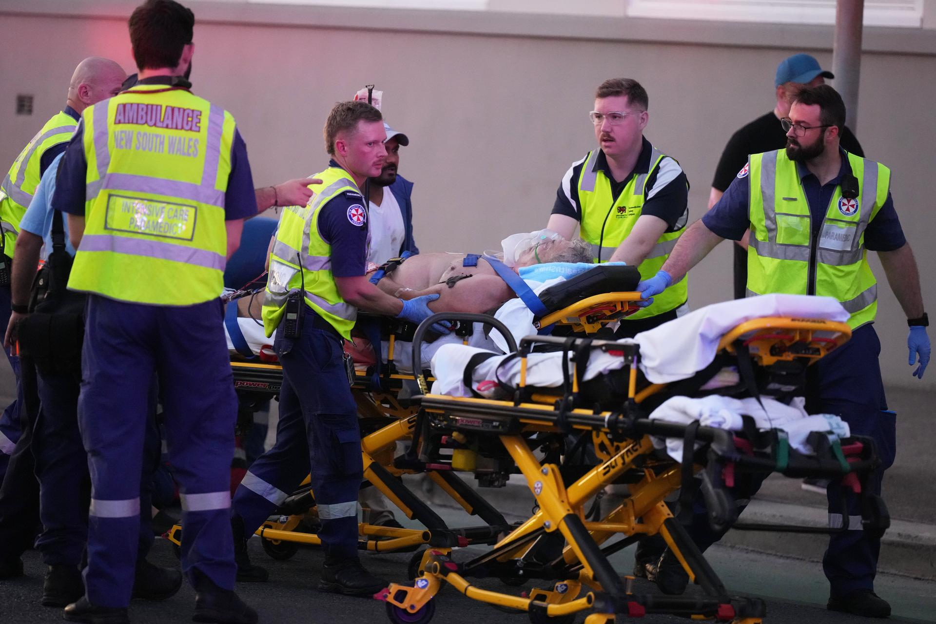 Emergency workers transport a person on a stretcher after a reported shooting at Bondi Beach in Sydney on Sunday. (AP Photo/Mark Baker)