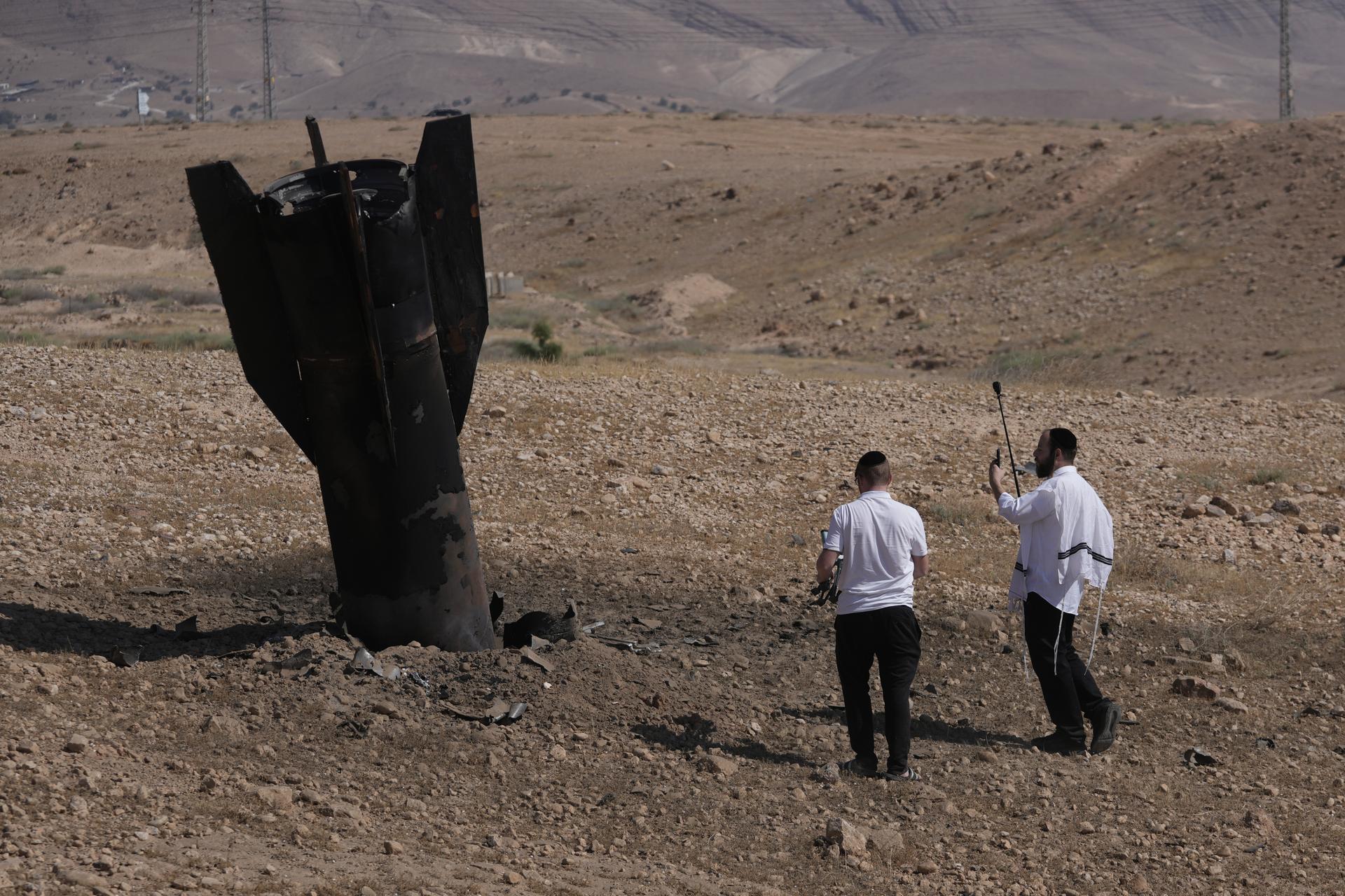 People inspect the wreckage of an Iranian missile that landed near the West Bank city of Jericho Monday. 
