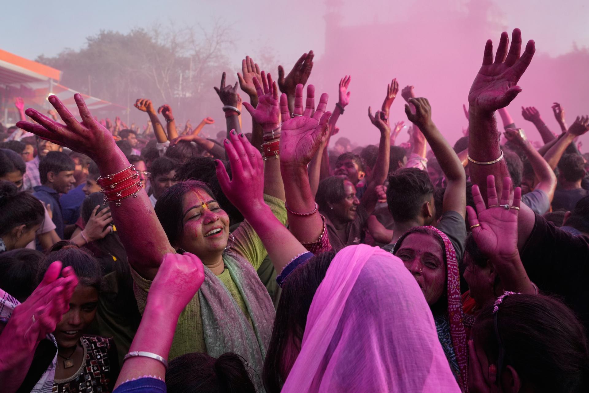 Devotees dance and sing during Holi festival celebrations as colored water is sprayed from above at the Shri Krishna Janmabhoomi Temple complex in Mathura, India, on Friday.