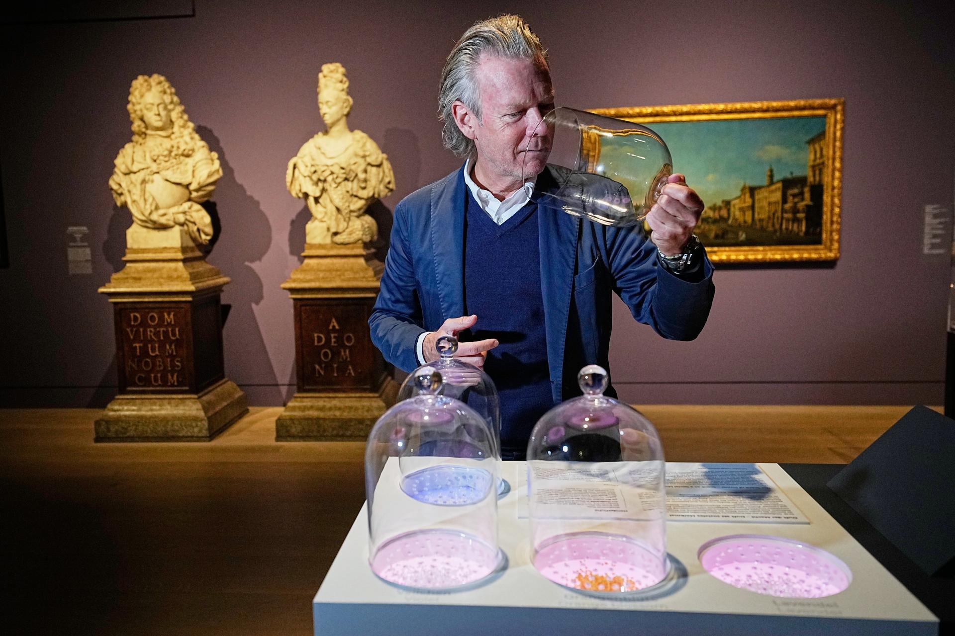 Curator Robert Mueller-Gruenow smells samples during the exhibition 