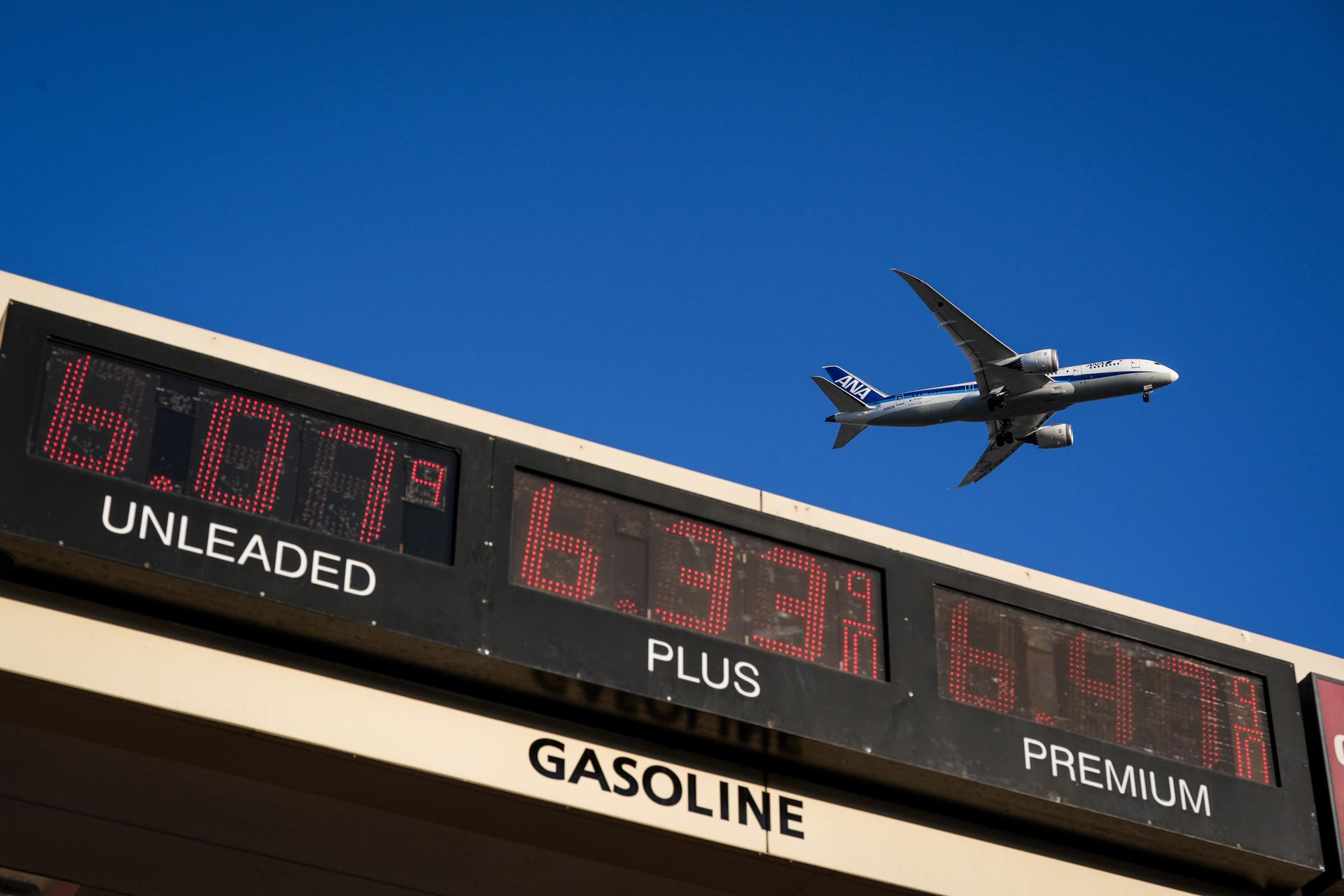 An ANA jet flies above a gas station in Inglewood, Calif., on Wednesday. (AP Photo/Jae C. Hong)