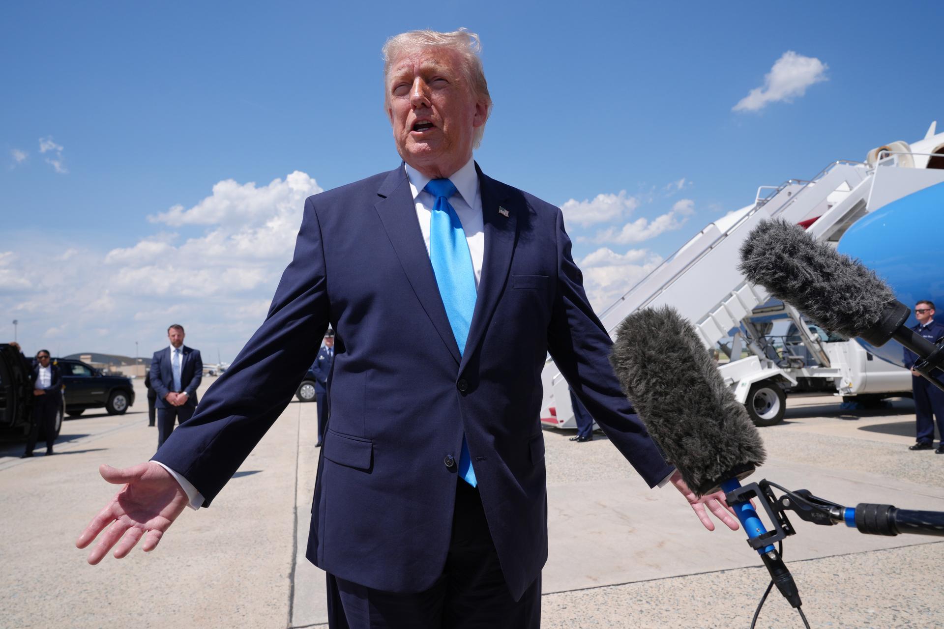 President Donald Trump speaks to the press after returning and stepping off Air Force One on Wednesday, at Joint Base Andrews, Md.