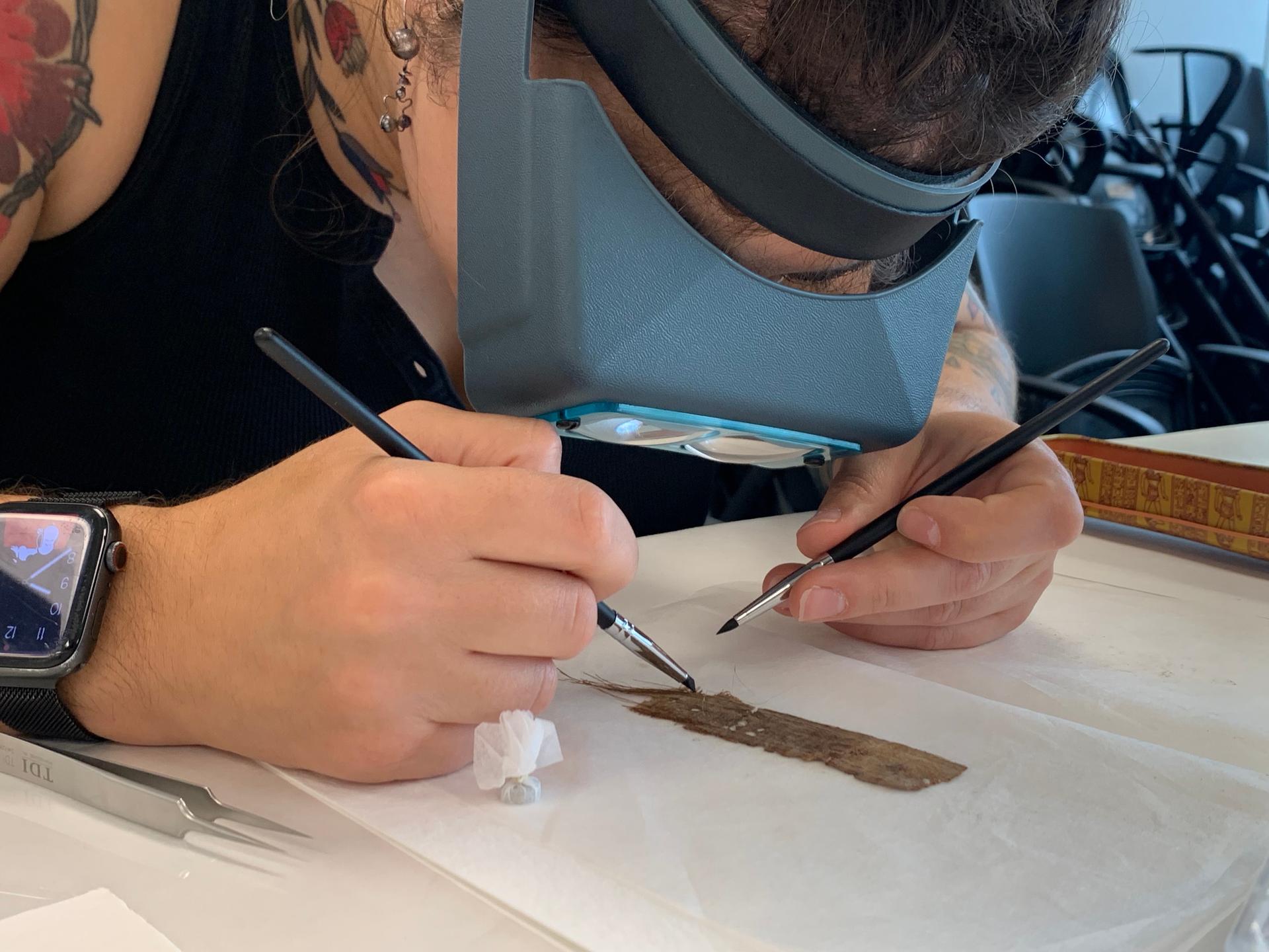 Papyrus Conservation Summer Seminar student Mimi Zycherman examines a papyrus fragment at the University of Michigan, Aug. 6, in Ann Arbor, Mich.