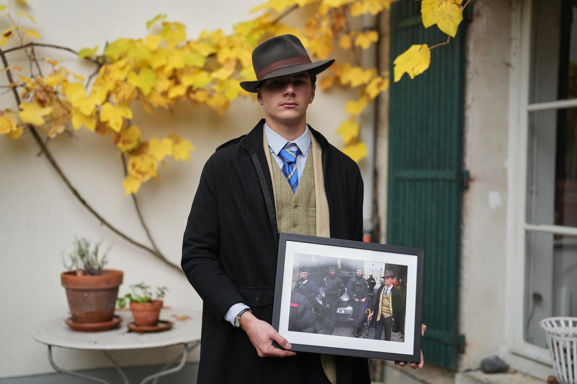 Pedro Elias Garzon Delvaux poses on Saturday with an Associated Press photo of him outside the Louvre on the day of the crown jewels heist. (AP Photo/Thibault Camus)