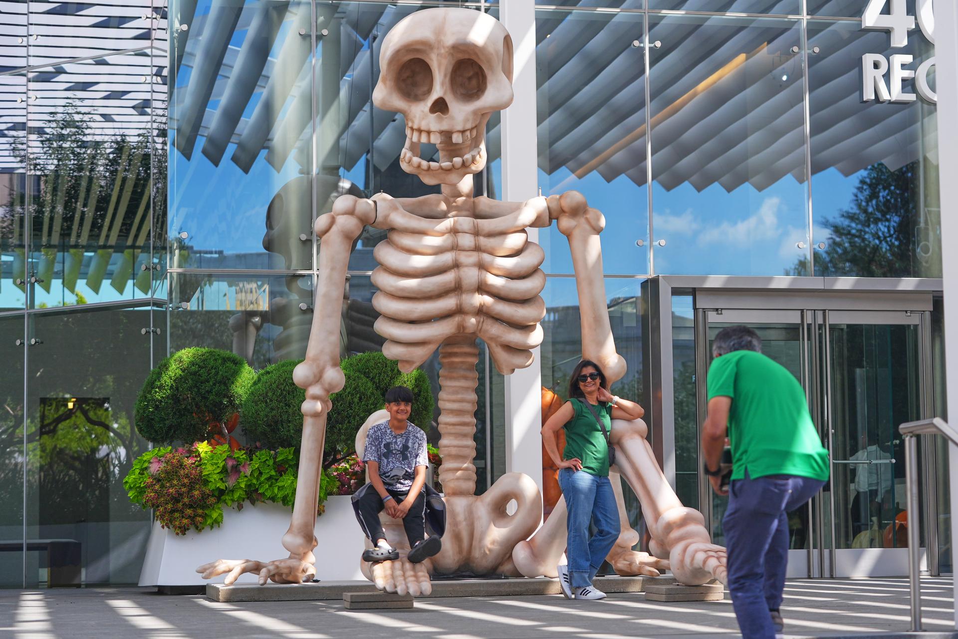 Sam Desai, right, takes a Halloween-themed photo of his wife, Sonia Desai, and son, Rishan Desai, in downtown Dallas, Sept. 27, 2025. (AP Photo/LM Otero, File).