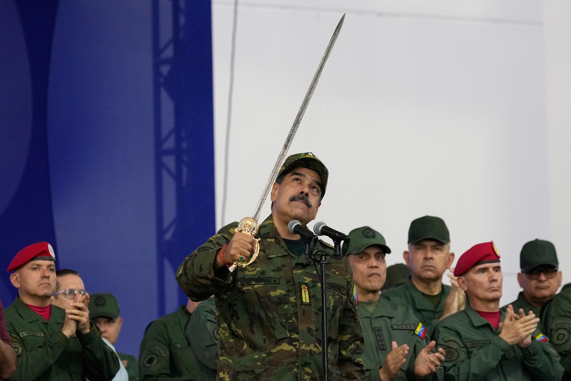 Venezuelan President Nicolas Maduro brandishes a sword said to have belonged to independence hero Simon Bolivar during a civic-military event in Caracas, Venezuela, on Tuesday. (AP Photo/Ariana Cubillos)