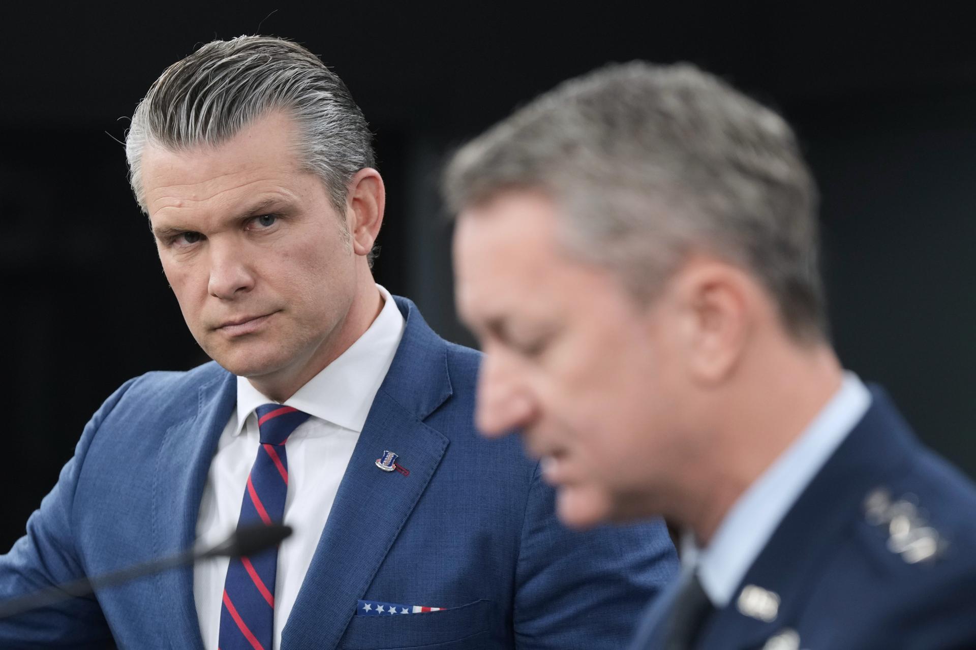 Defense Secretary Pete Hegseth listens to Chairman of the Joint Chiefs of Staff Gen. Dan Caine, during a press briefing at the Pentagon on March 2. (AP Photo/Mark Schiefelbein).