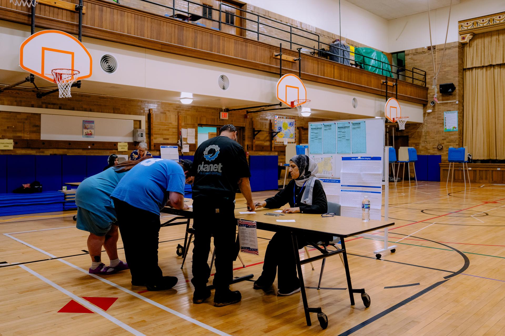 People prepare to vote at Oakman Elementary School Tuesday, in Dearborn, Mich. 
