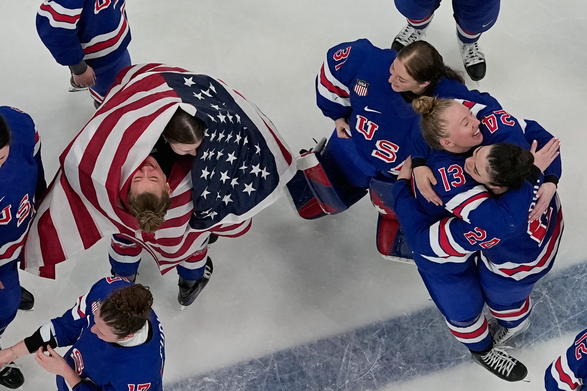 Team United States players celebrate after beating Canada 2-1 in overtime in the women's ice hockey gold medal game at the 2026 Winter Olympics, in Milan, Italy, Thursday. (AP Photo/David J. Phillip)