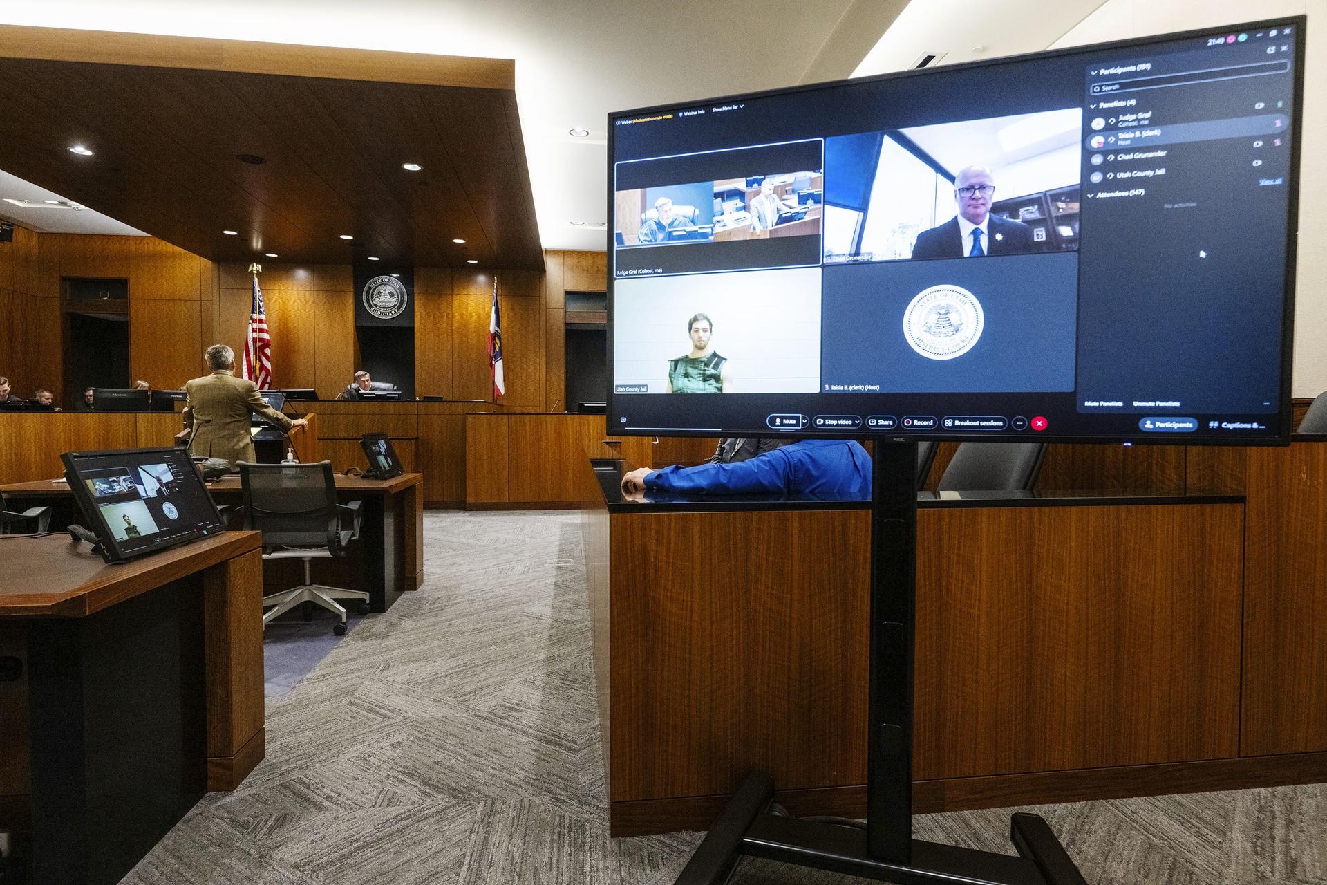 Defense attorney Greg Skordas, left, speaks before judge Tony Graf, back center left, as Tyler Robinson, accused of fatally shooting Charlie Kirk, attends a virtual court hearing from prison on Tuesday, in Provo, Utah.