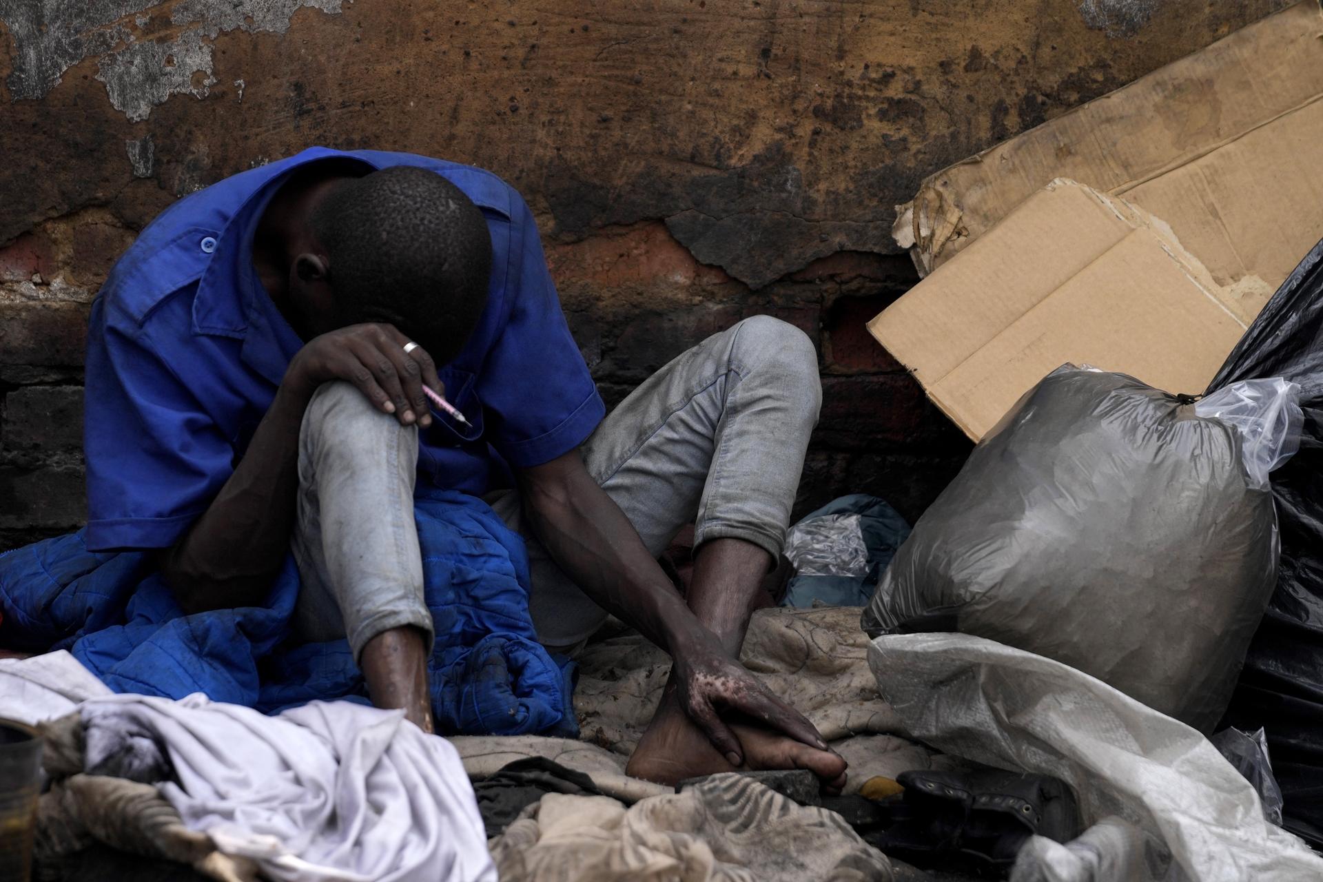 A homeless drug addict holds a syringe after injecting himself, on the outskirts of Pretoria, South Africa, Wednesday, March 5, 2025. (AP Photo/Themba Hadebe).