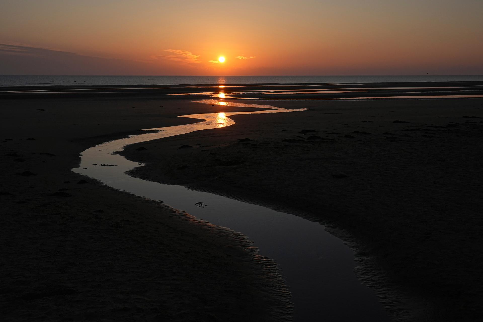 The sun rises over Omaha Beach near Colleville-sur-Mer Normandy, June 6, 2024, 80 years after the D-Day landings. 