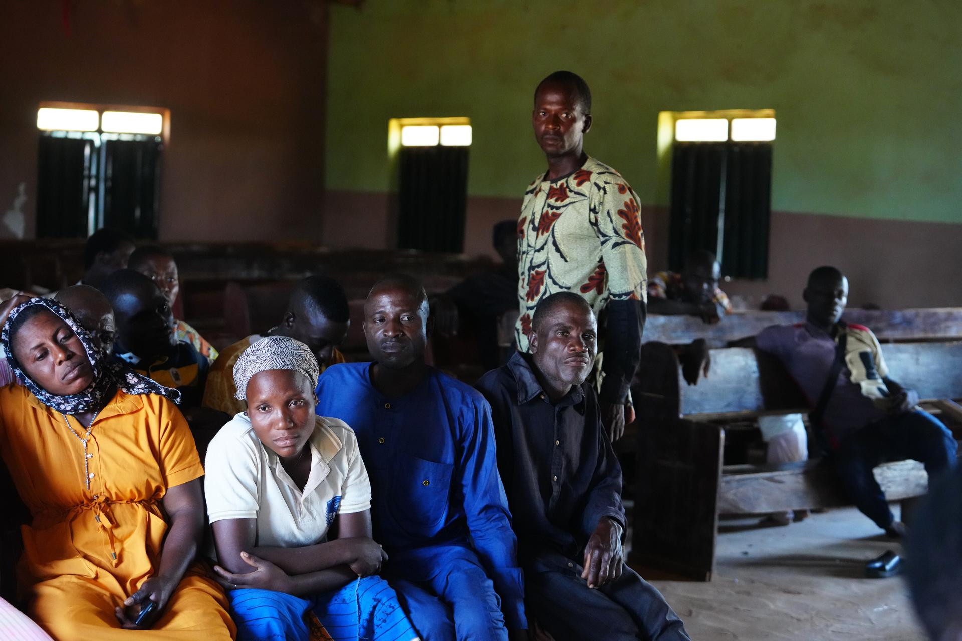 The Rev. Micah standing, right, a pastor who was kidnapped along with others from a church service in November 2024, speaks with church members in Nigeria on Nov. 6. (AP Photo/Sunday Alamba)