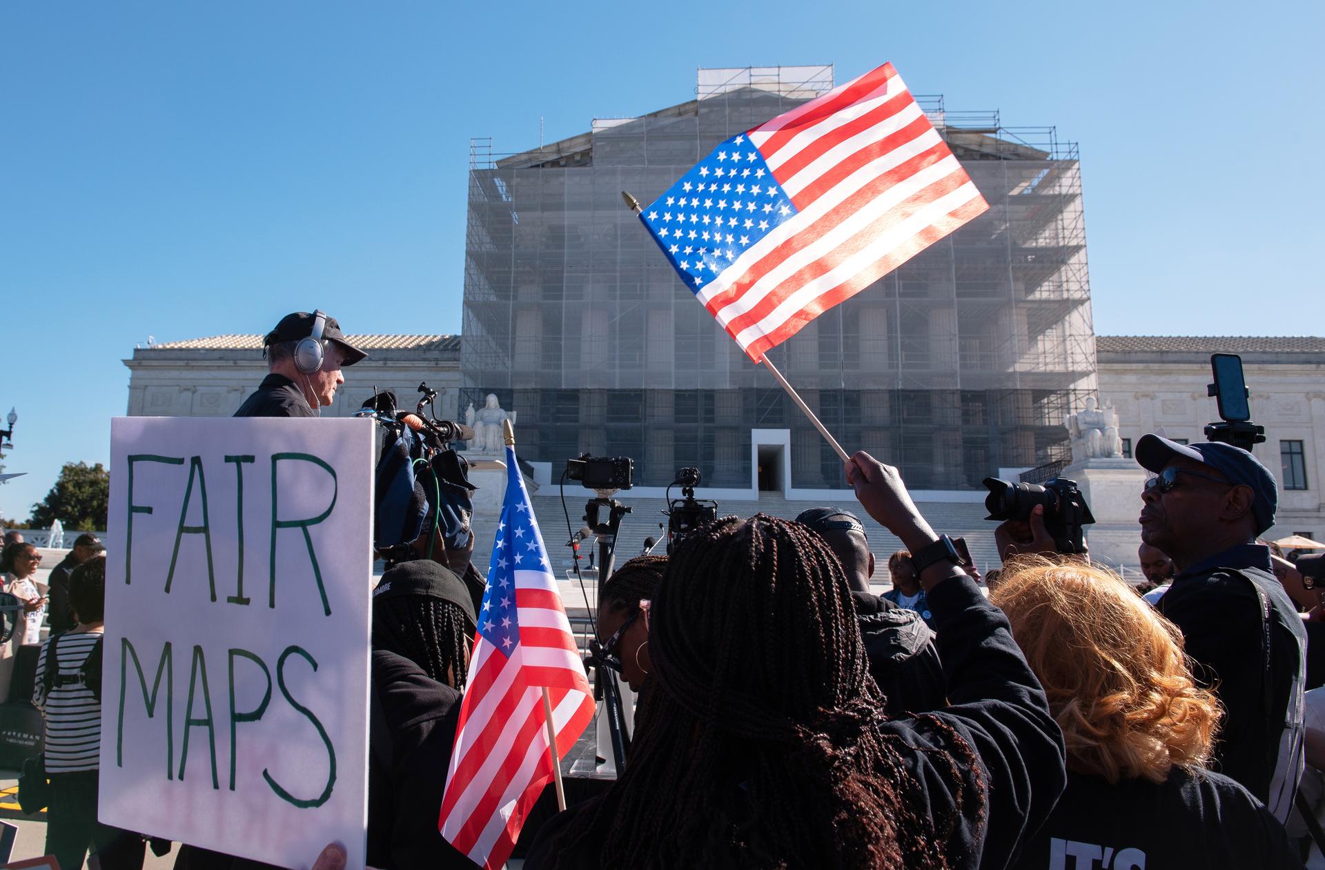 Voting rights activists gather outside the Supreme Court in Washington on Wednesday. (AP Photo/Cliff Owen)