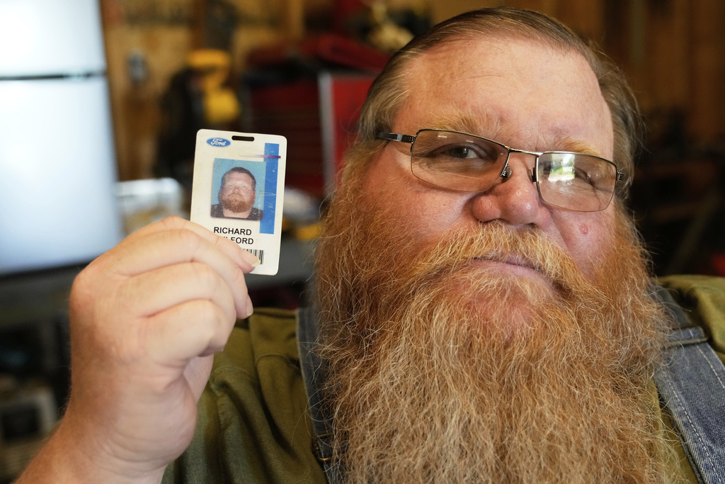Richard Guilford poses for a portrait with an ID card from his recently recovered wallet that he lost 11 years ago Thursday, Aug. 14, 2025, in Petersburg, Mich. (AP Photo/Ryan Sun)
