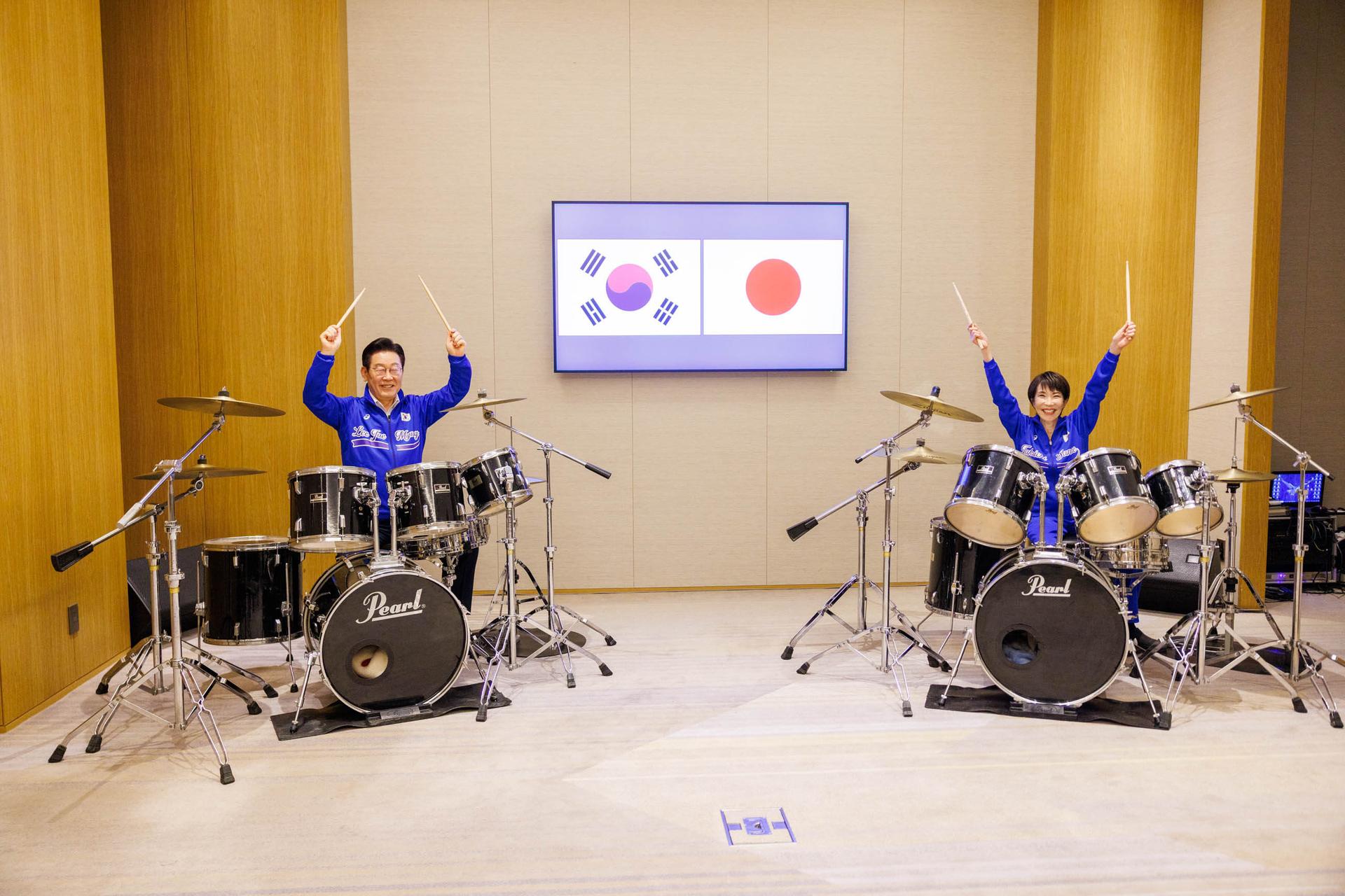 In this photo released on the official website of the Prime Minister's Office of Japan, Japanese Prime Minister Sanae Takaichi, right, and South Korean President Lee Jae Myung play drums together after their talks in Nara, western Japan, Tuesday.