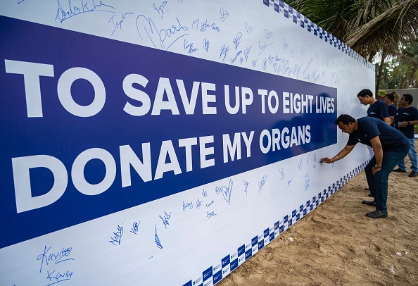 A wall has organ donation slogans and signatures on it.
