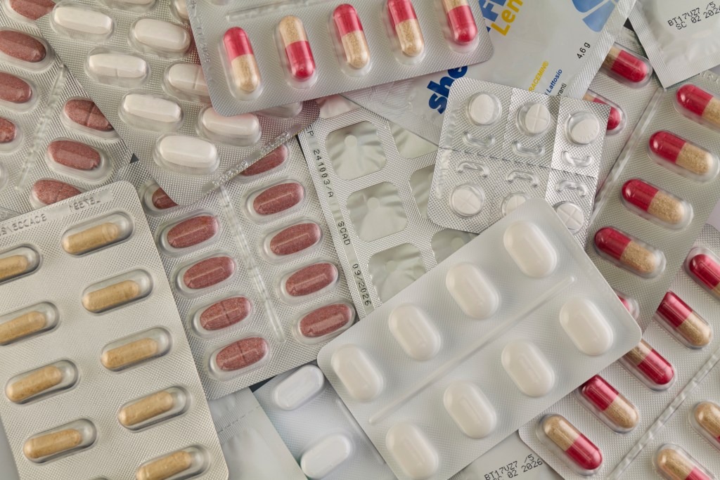 Blister packs of many different types of pills in a pile.