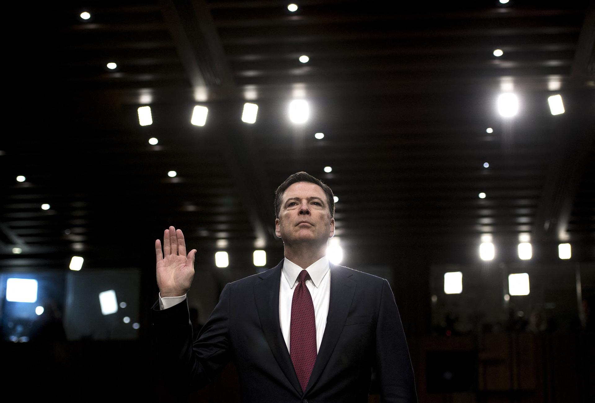 James Comey raises his right hand before testifying to Congress.