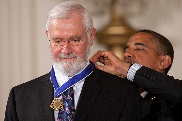 William Foege stands as President Barack Obama puts a medal around his neck.