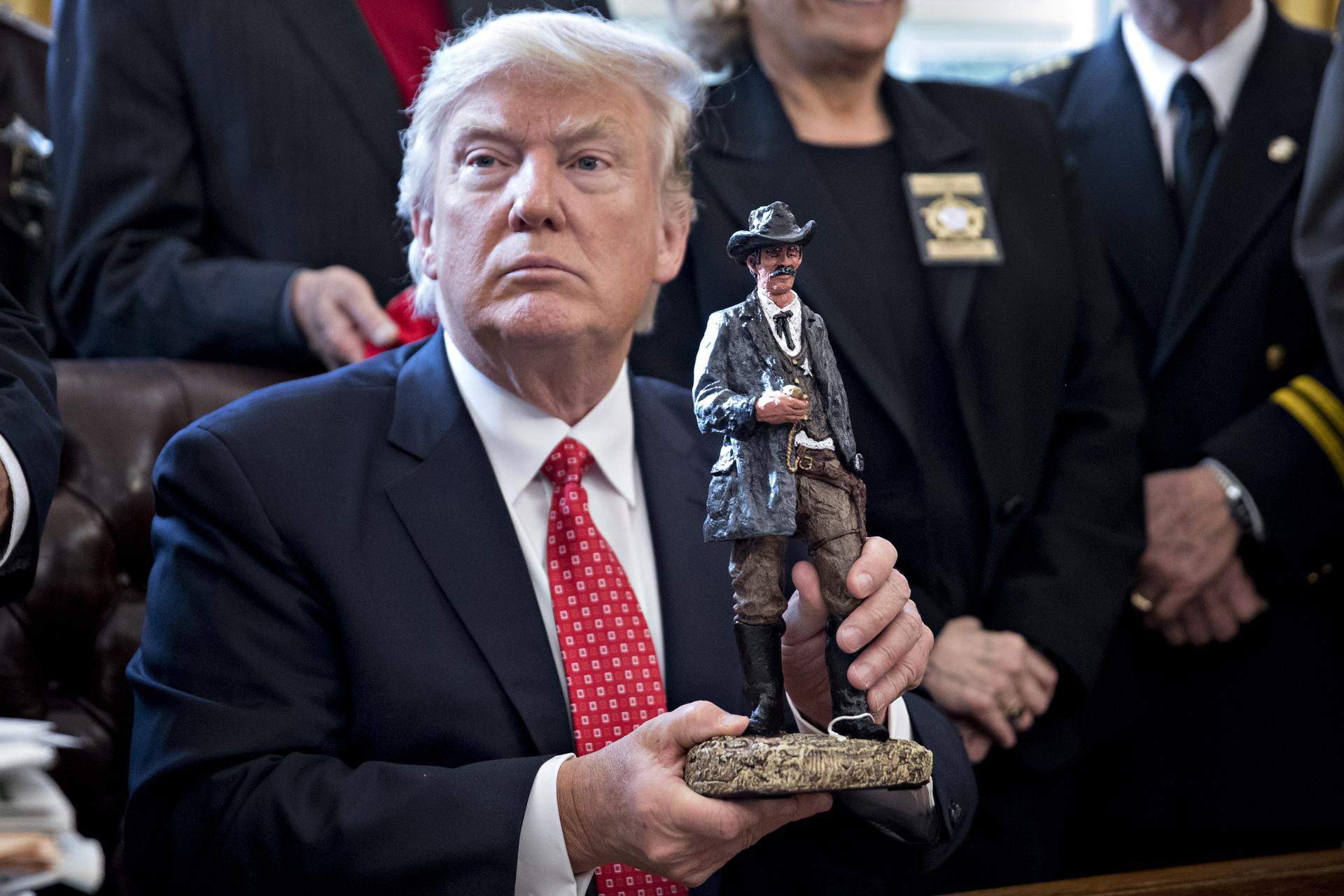 Trump holding a statue