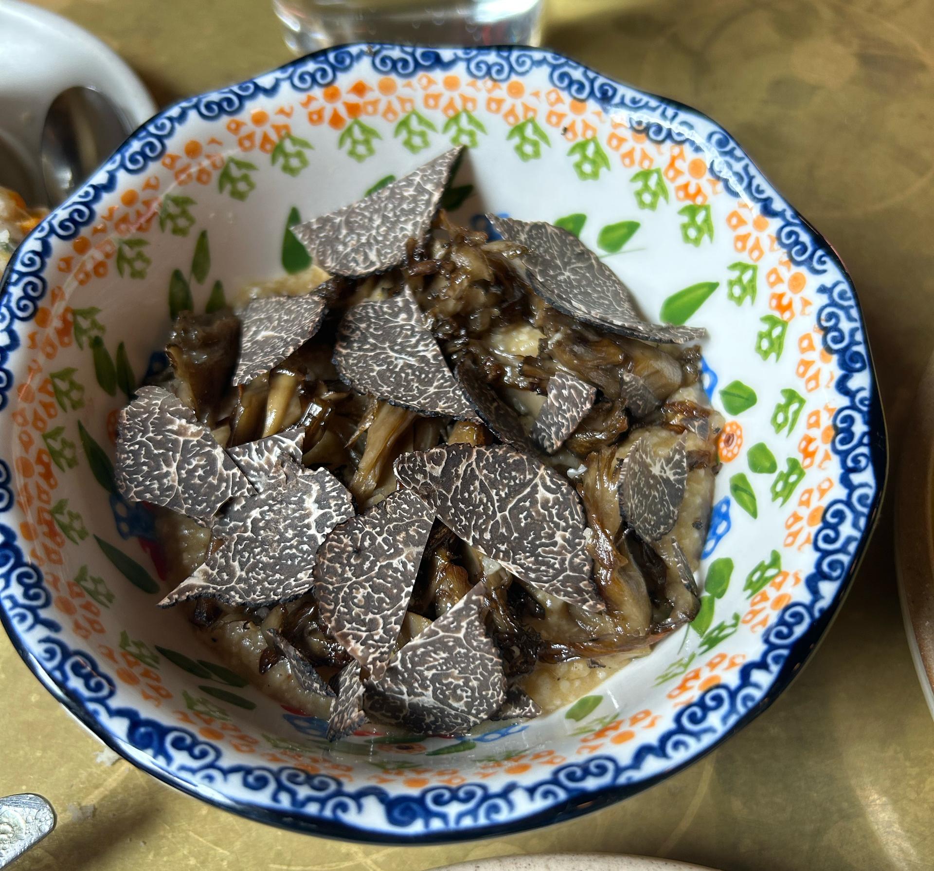 A bowl of truffles on top of grits
