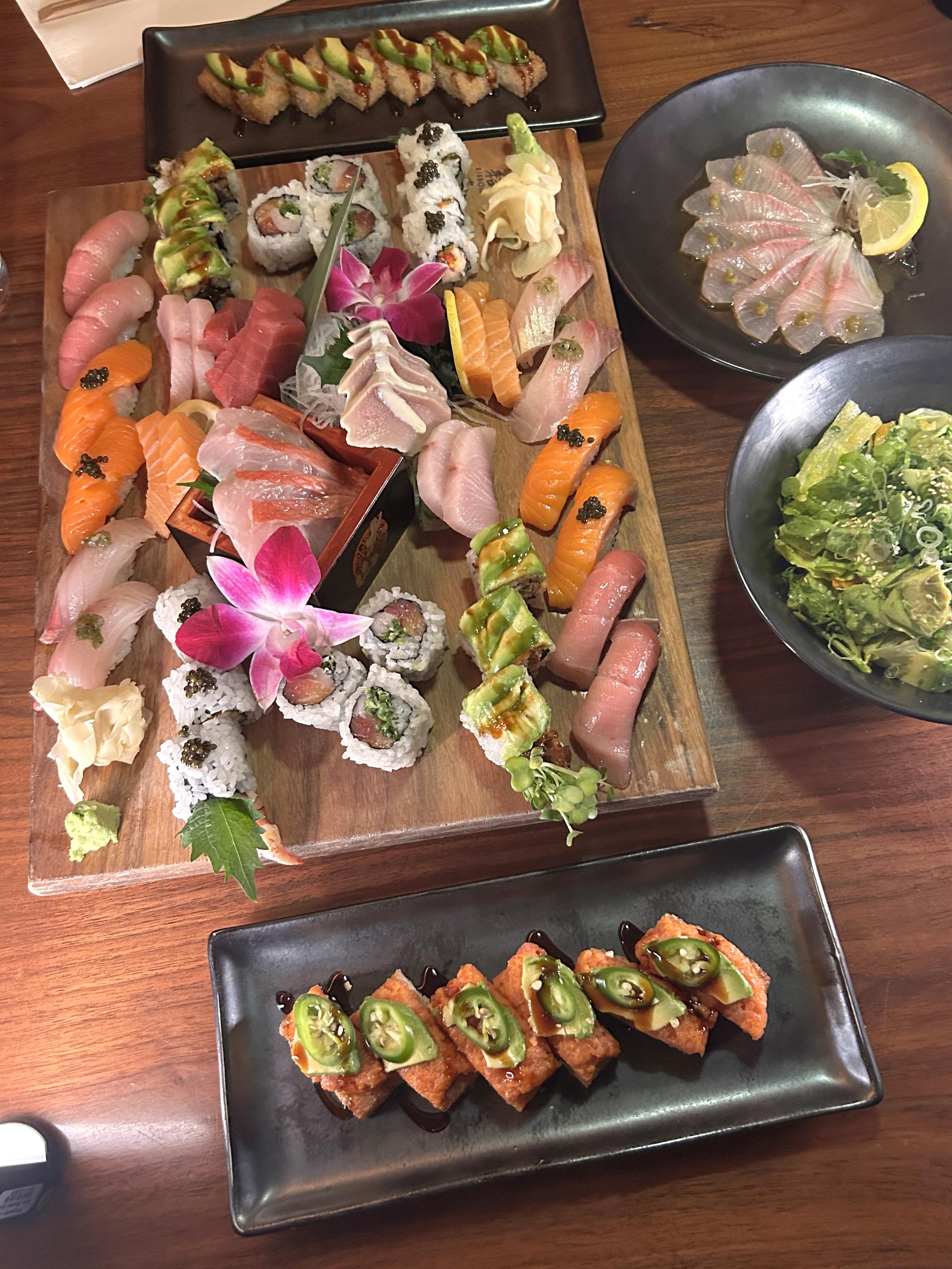 A platter of sushi next to a plate of sushi.