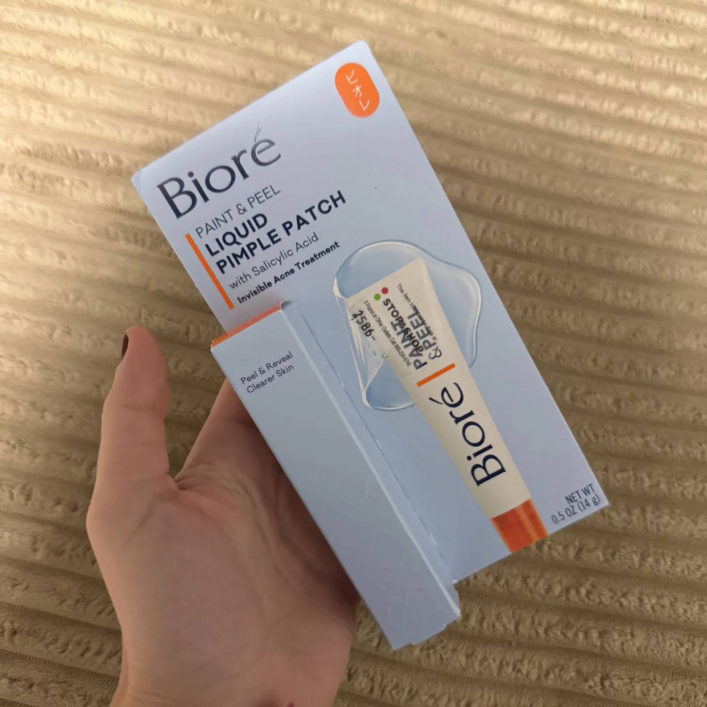 Woman holding a package of Bioré Pimple Patch.