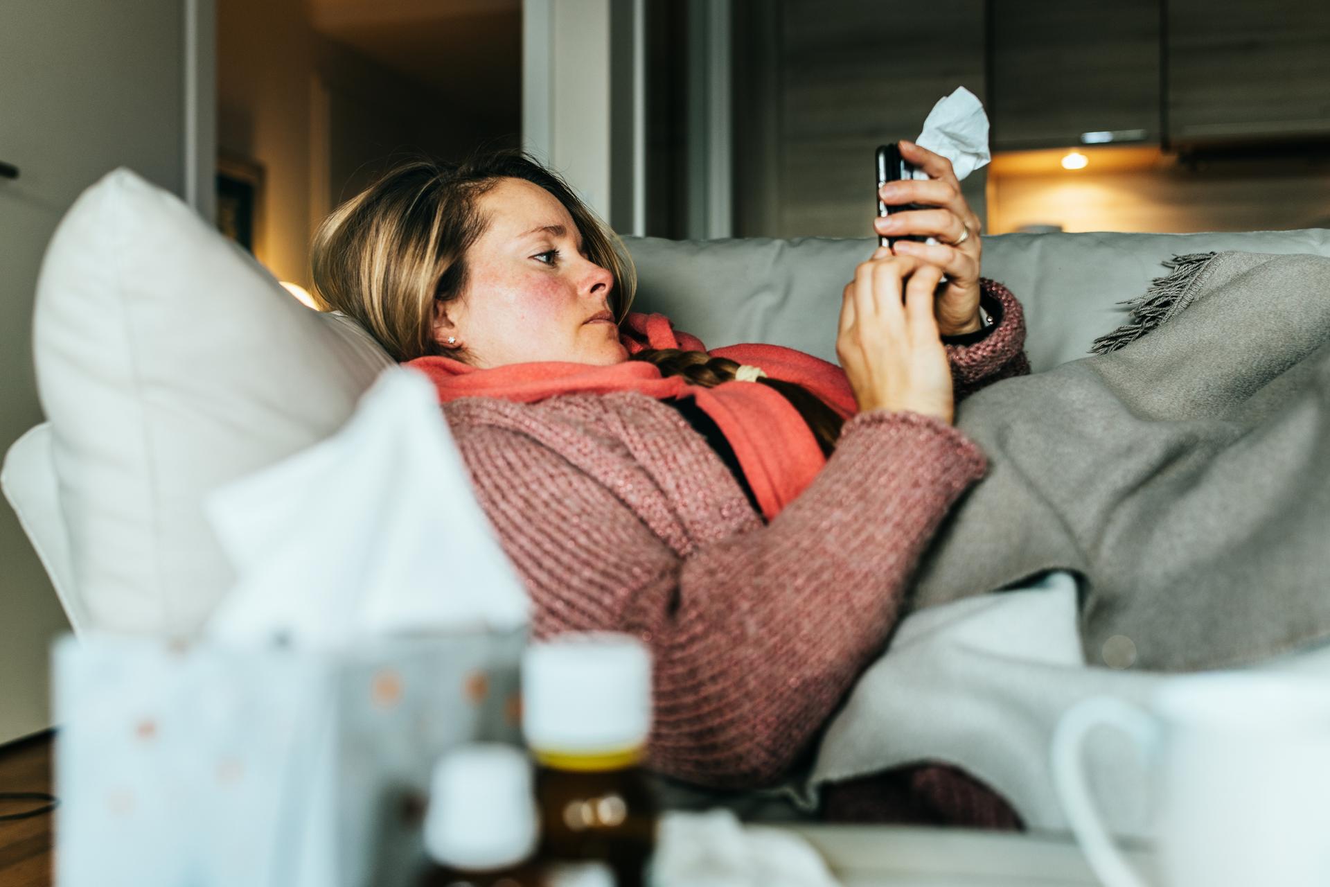 Woman lying on a couch feeling sick