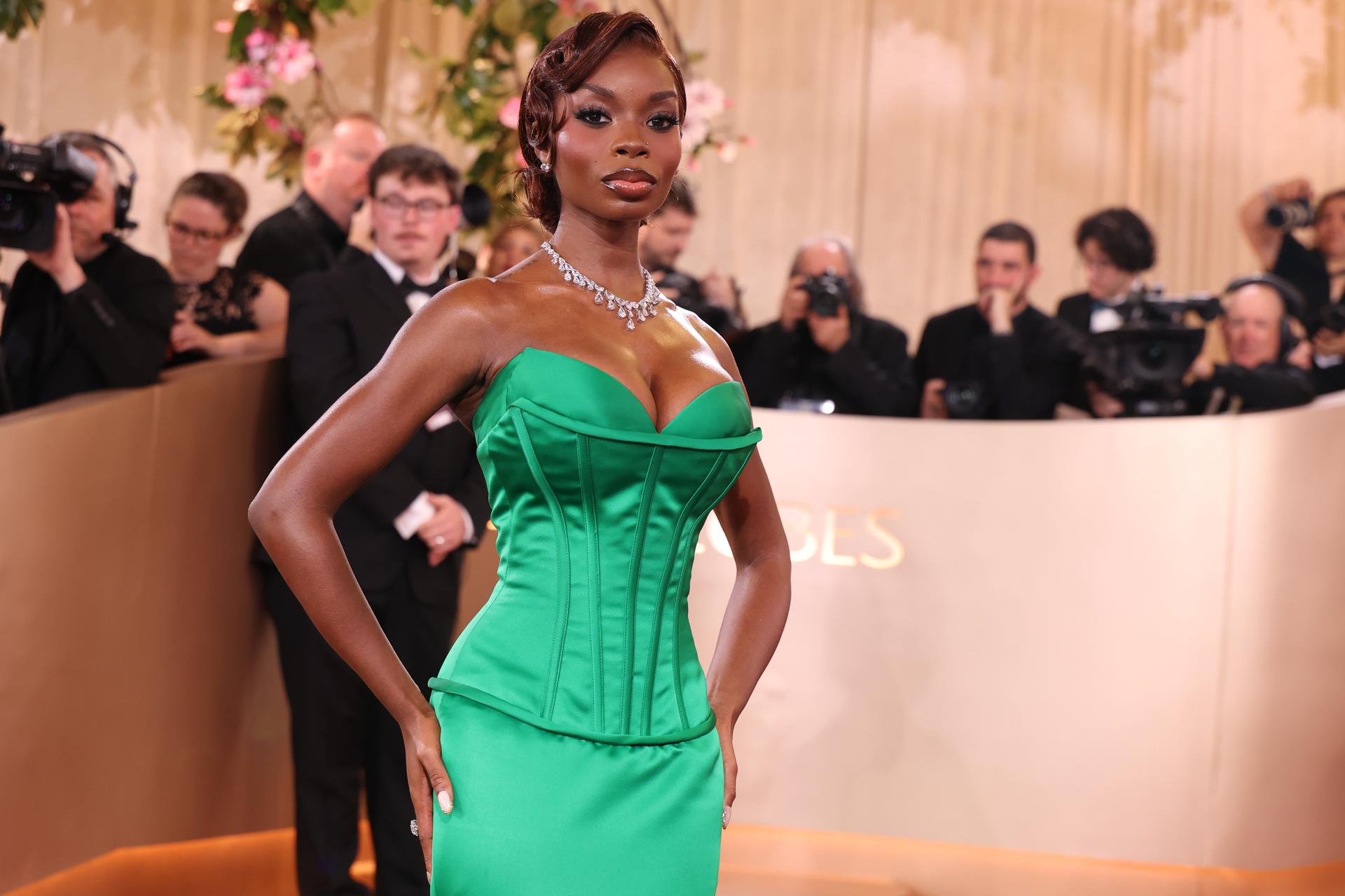 A woman wearing a green strapless mermaid gown.
