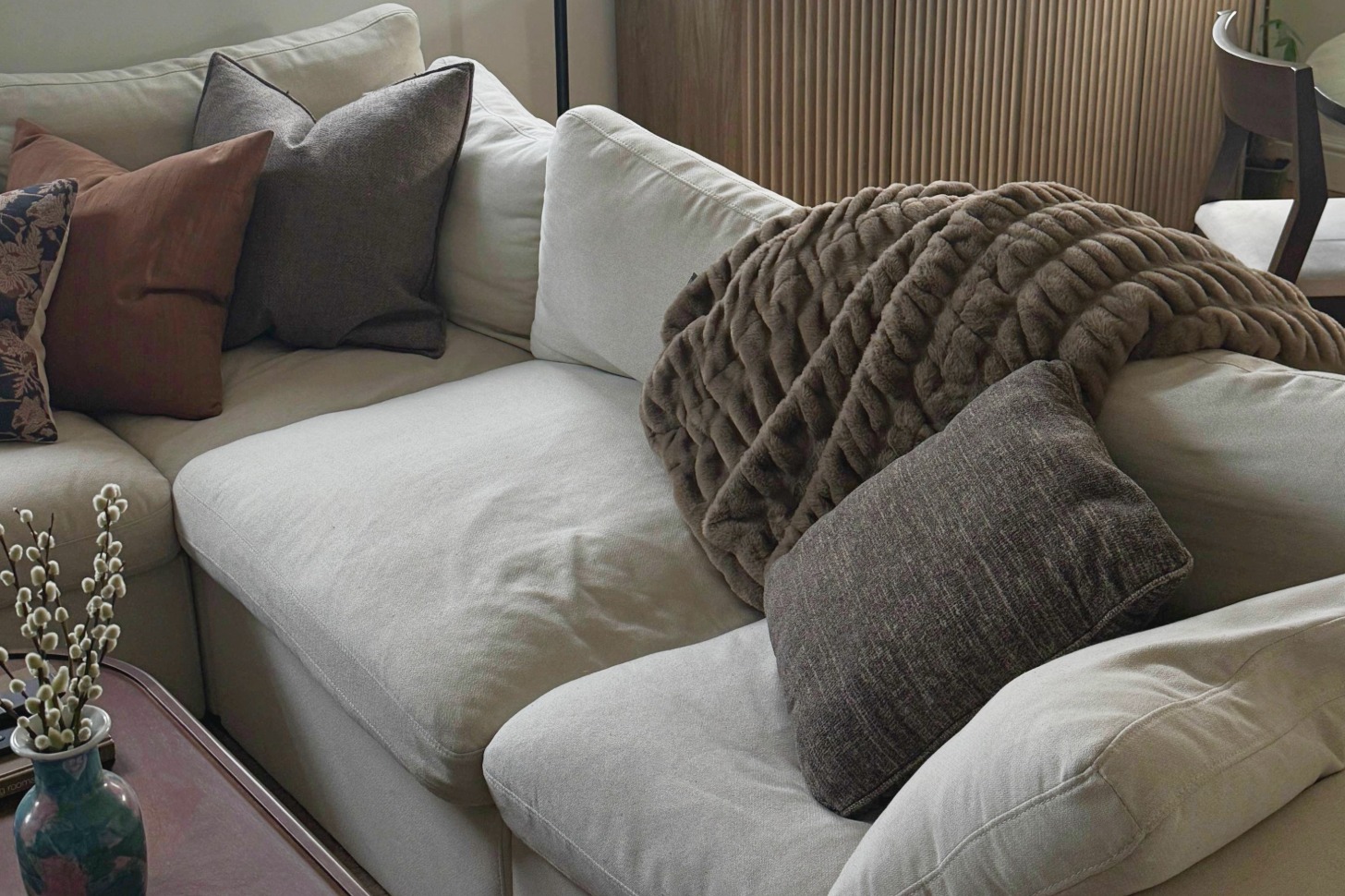 A couch with a brown blanket.