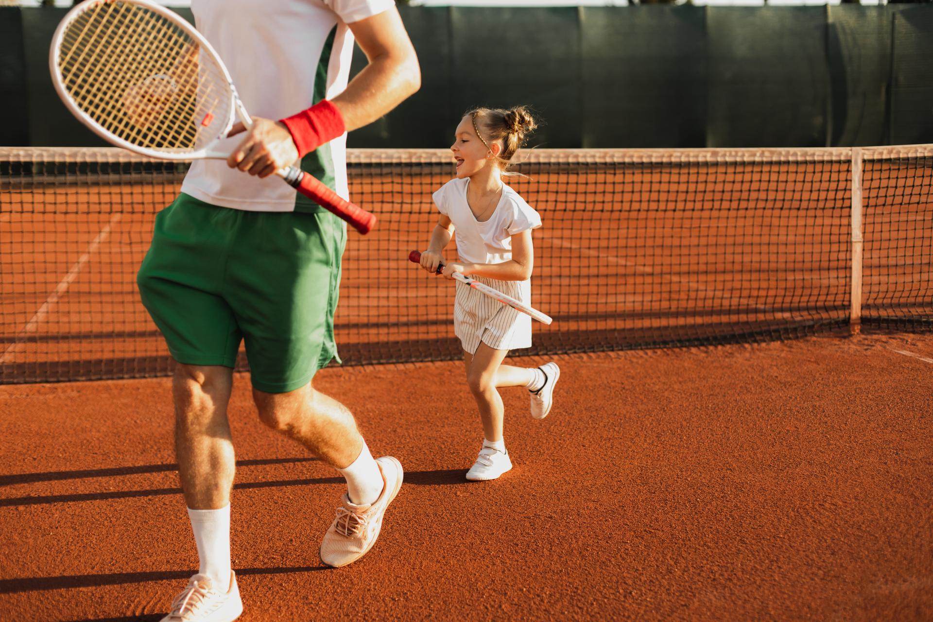 Daughter and dad playing tennis