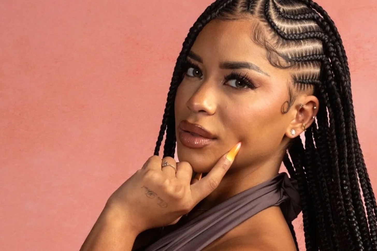 Amaya Papaya posing with a hand on her face.