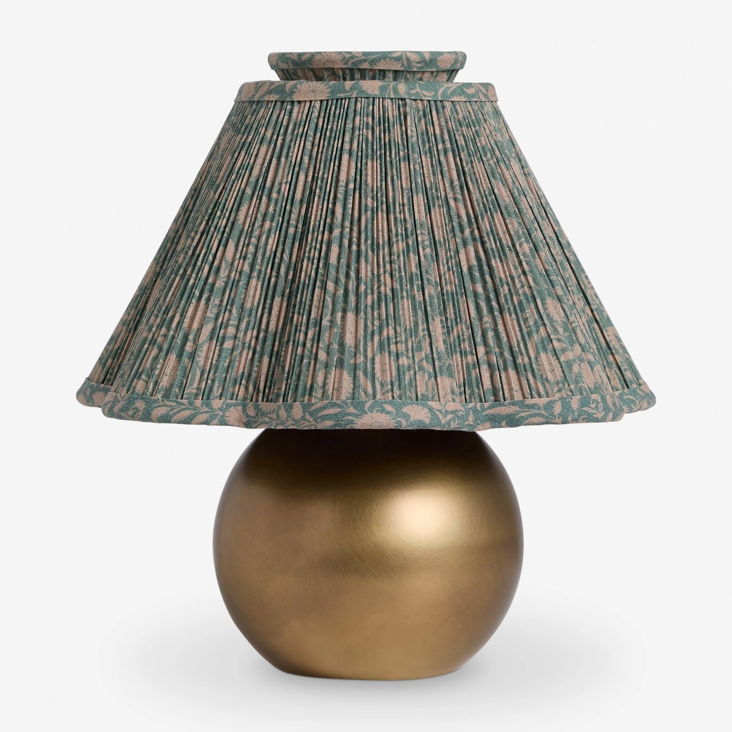 A gold table lamp with a floral green shade. 