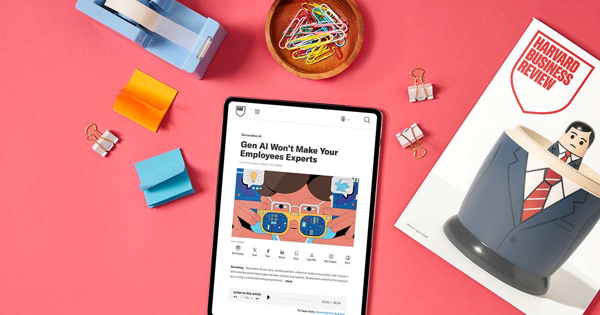 A tablet displaying the Harvard Business Review site, a copy of HBR magazine, sticky notes, tap dispenser, paperclips and binder clips sitting on a red surface.