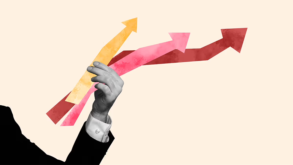 A hand holding three colorful upward-pointing arrows.