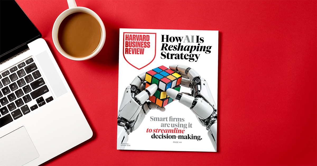 Harvard Business Review magazine featuring ‘How AI Is Reshaping Strategy,’ with robotic hands holding a colorful puzzle cube.