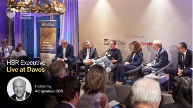 Speakers seated on a stage during an HBR Executive Live at Davos panel event, with audience members visible in the foreground.