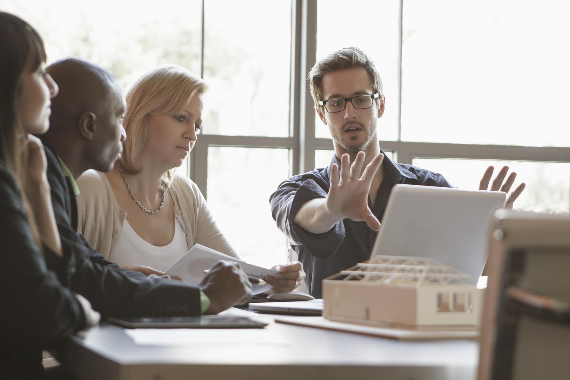 Group gathered around a laptop during a workplace discussion.