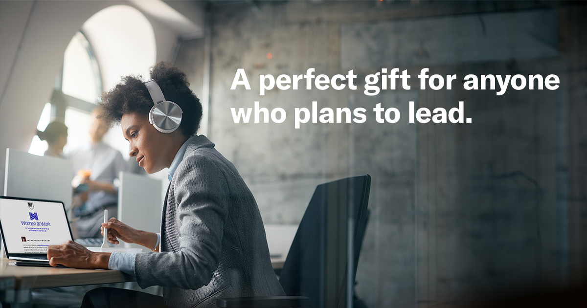 A person in headphones works on a laptop in a modern office. Text reads, 'A perfect gift for anyone who plans to lead,' suggesting focus and leadership.