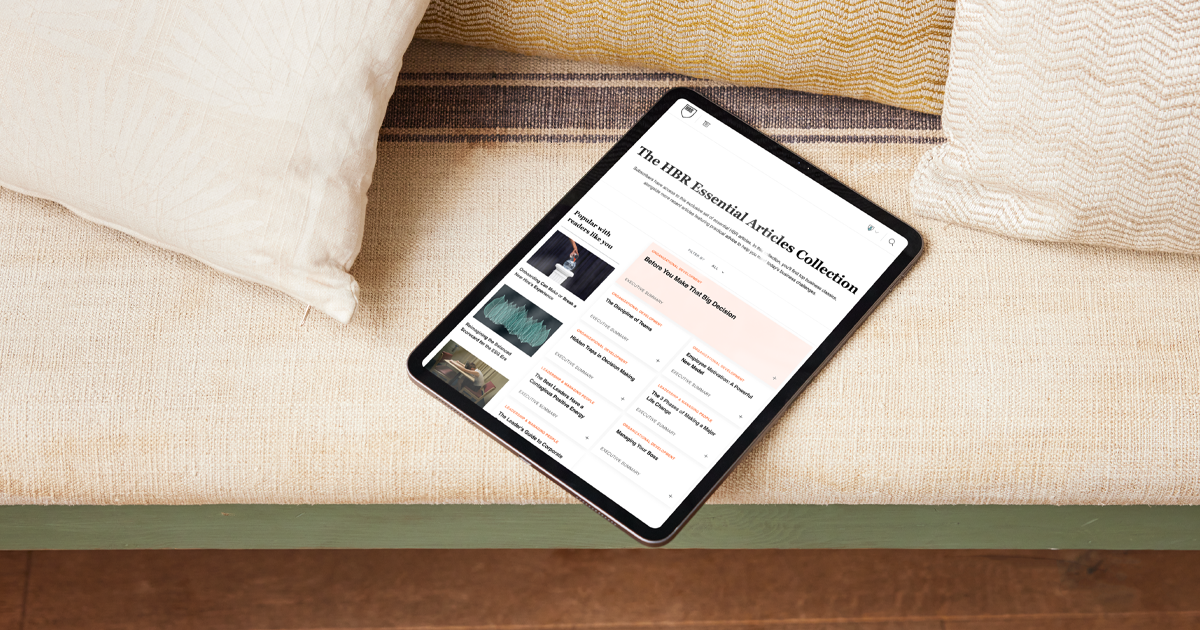 Tablet resting on a couch shows the HBR Essential Articles Collection page with a list of articles.