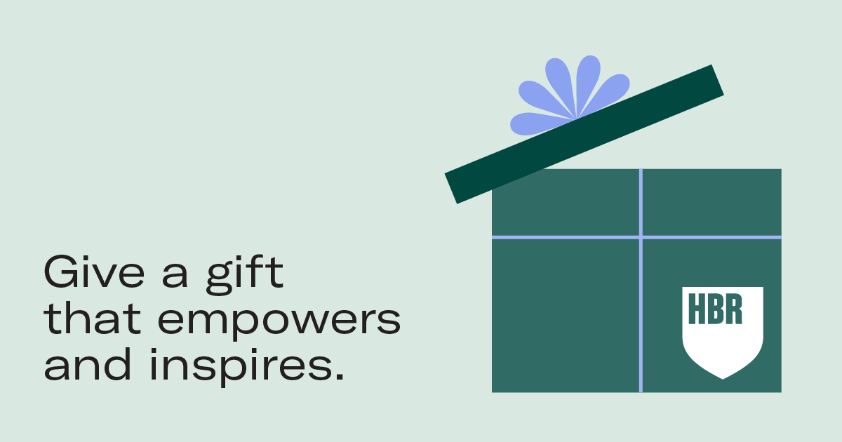 Person in black coat holds a tablet and takeaway coffee cup while seated on an orange bench. Autumn leaves scattered on the ground suggest a cozy fall setting.