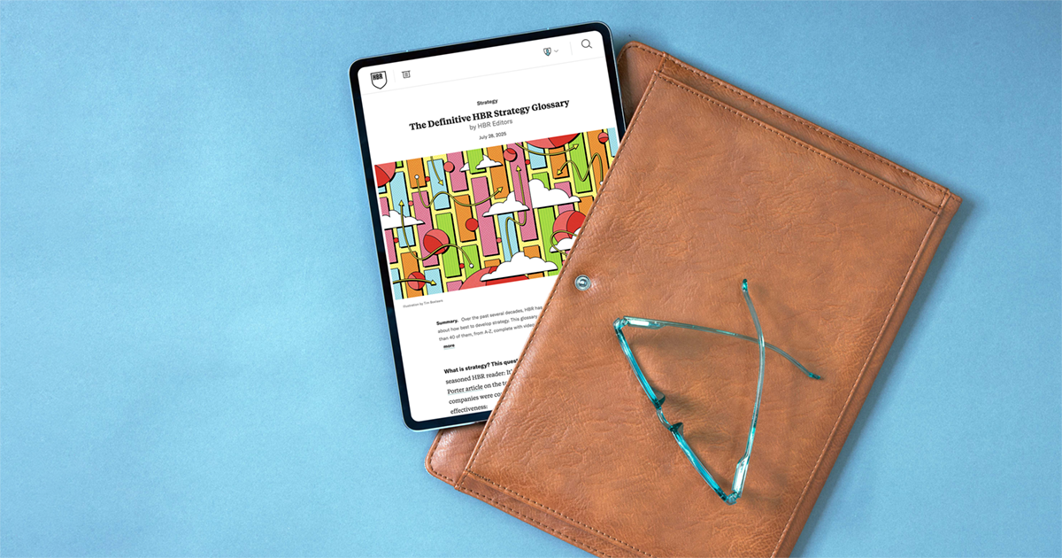 Tablet displaying an HBR strategy article beside a brown leather folio and teal eyeglasses on a blue surface.