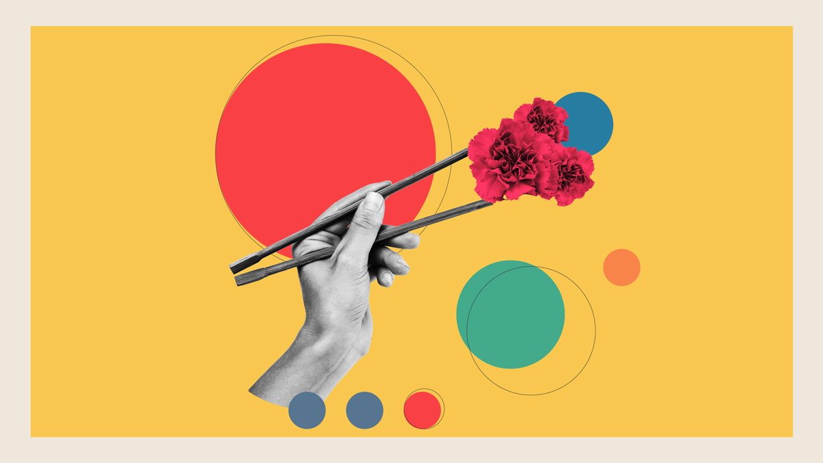 An image of a hand with chopsticks holding a red flower between them against a yellow background with bright color spots.